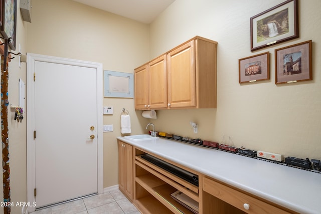 kitchen featuring light brown cabinets, light tile patterned floors, and sink