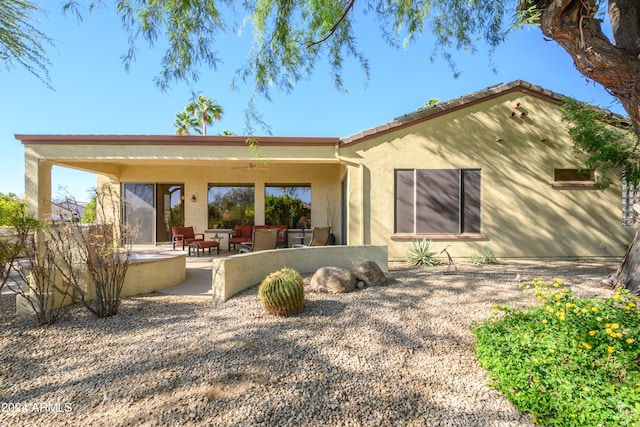 back of property with a patio area and an outdoor living space