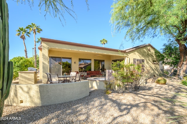 rear view of house featuring an outdoor living space and a patio