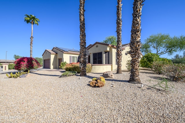 view of front of home featuring solar panels and a garage