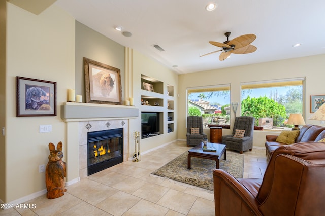 tiled living room featuring a fireplace, built in shelves, and ceiling fan