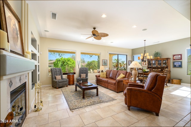 tiled living room with ceiling fan with notable chandelier