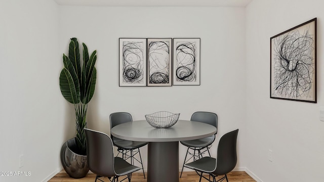 dining room with baseboards and wood finished floors