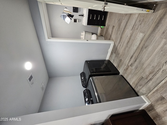 clothes washing area featuring washer and dryer, visible vents, and laundry area