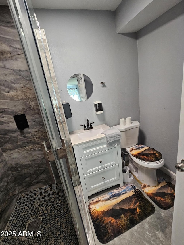 full bath featuring toilet, a stall shower, and vanity