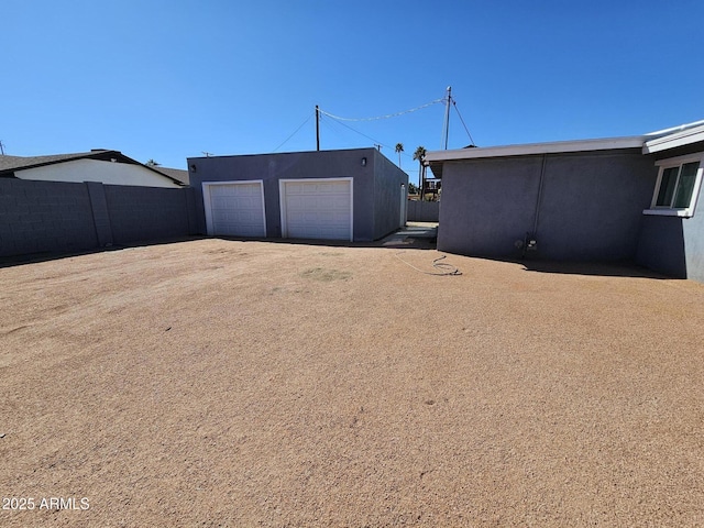 view of yard with an outdoor structure, fence, and a detached garage