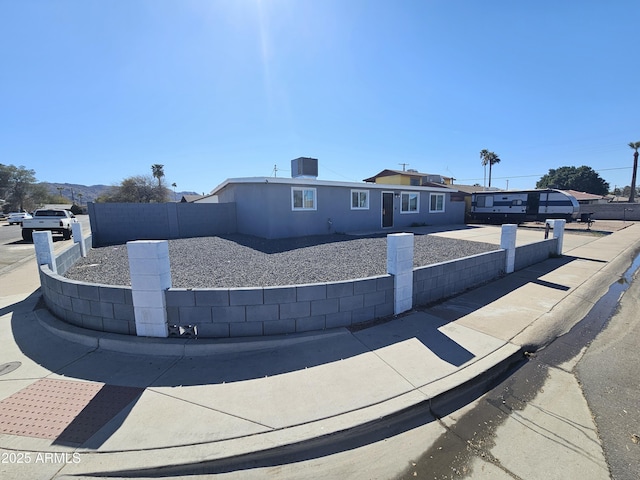 view of front of property featuring stucco siding and fence