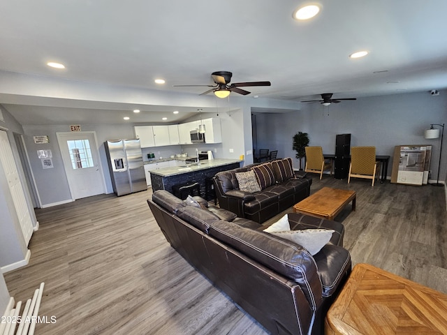 living room featuring recessed lighting, light wood-style flooring, baseboards, and a ceiling fan