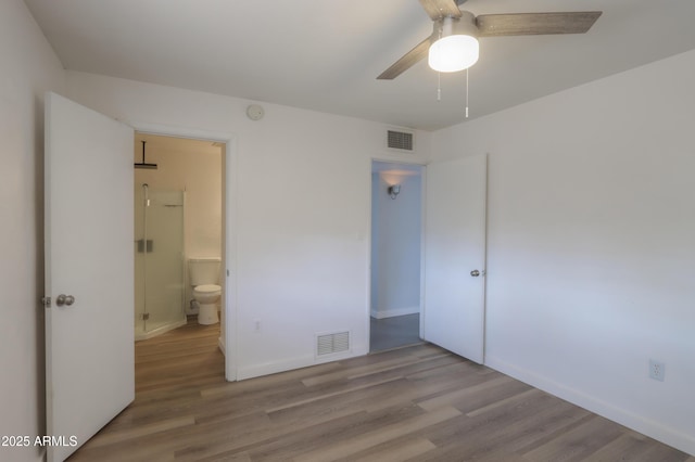 512 N Ironwood, Mesa, AZ 85201 - unfurnished bedroom with wood finished floors, baseboards, ensuite bathroom, and ceiling fan
