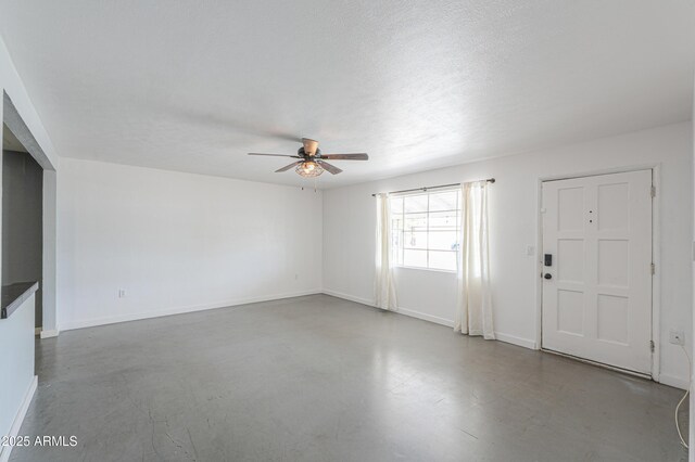 512 N Ironwood, Mesa, AZ 85201 - unfurnished living room with a ceiling fan, baseboards, and concrete floors
