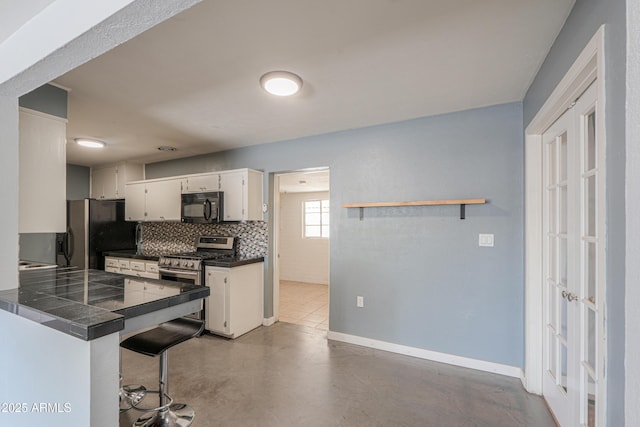 512 N Ironwood, Mesa, AZ 85201 - kitchen featuring black microwave, stainless steel range with gas stovetop, refrigerator with ice dispenser, decorative backsplash, and concrete floors