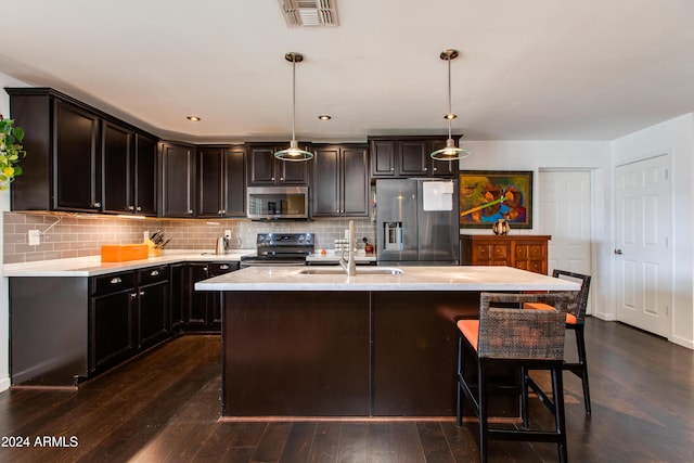 kitchen with pendant lighting, sink, an island with sink, dark hardwood / wood-style flooring, and stainless steel appliances