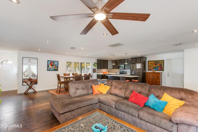 living room with ceiling fan and dark wood-type flooring