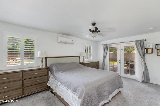 carpeted bedroom with ceiling fan, french doors, a wall mounted air conditioner, access to outside, and multiple windows