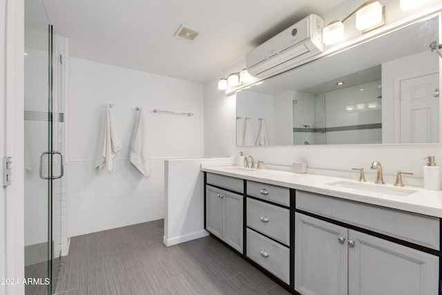 bathroom with vanity, a shower with shower door, and a wall unit AC