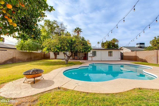 view of swimming pool with a yard, a fire pit, and a patio area