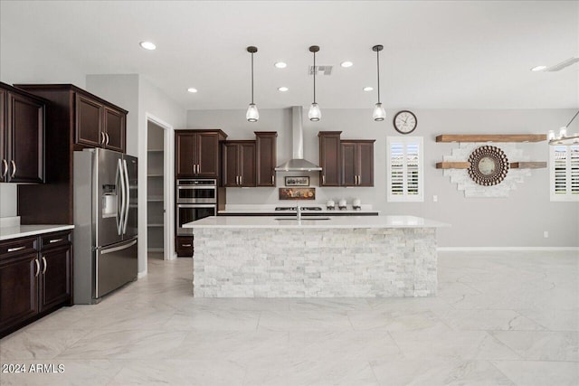 kitchen with wall chimney exhaust hood, a center island with sink, appliances with stainless steel finishes, and light tile patterned flooring