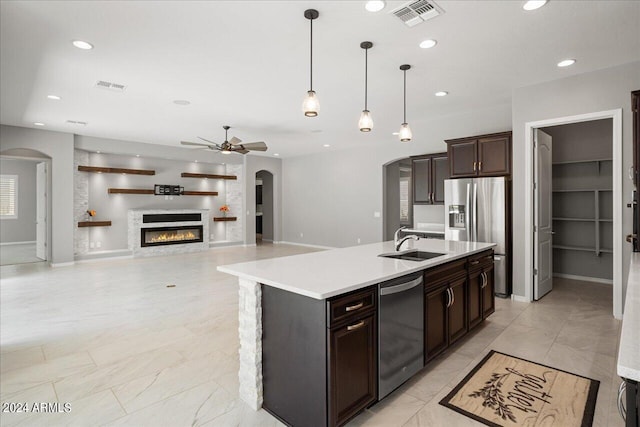 kitchen featuring decorative light fixtures, sink, a kitchen island with sink, light tile patterned floors, and ceiling fan