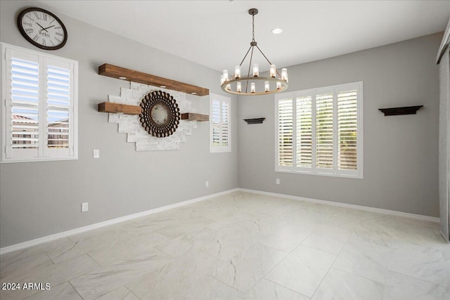 tiled empty room featuring a notable chandelier