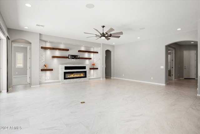 unfurnished living room with ceiling fan, light tile patterned floors, and a premium fireplace