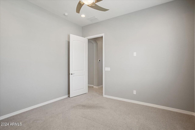 carpeted spare room featuring ceiling fan