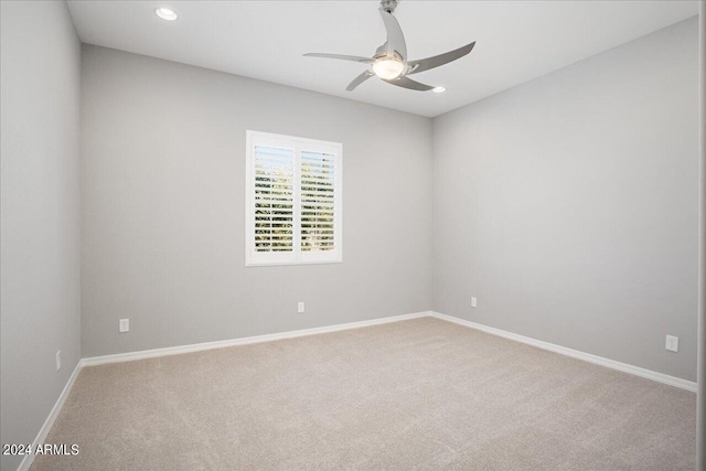 unfurnished room featuring ceiling fan and light carpet