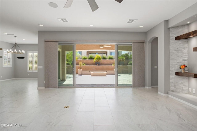 interior space with ceiling fan with notable chandelier and light tile patterned flooring