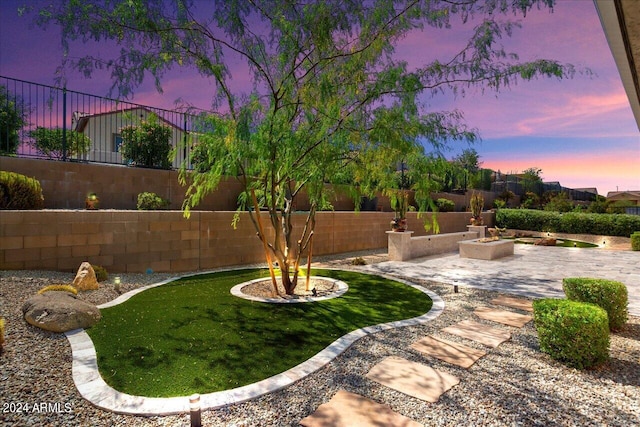 yard at dusk with a patio area