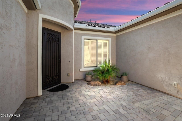 exterior entry at dusk with a patio