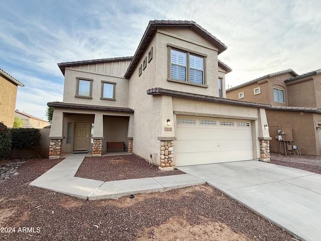 view of front facade with an attached garage, stone siding, concrete driveway, and stucco siding