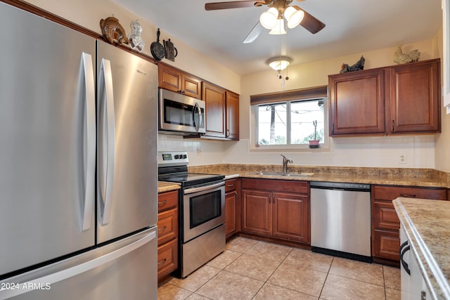 kitchen with ceiling fan, stainless steel appliances, light tile flooring, backsplash, and sink