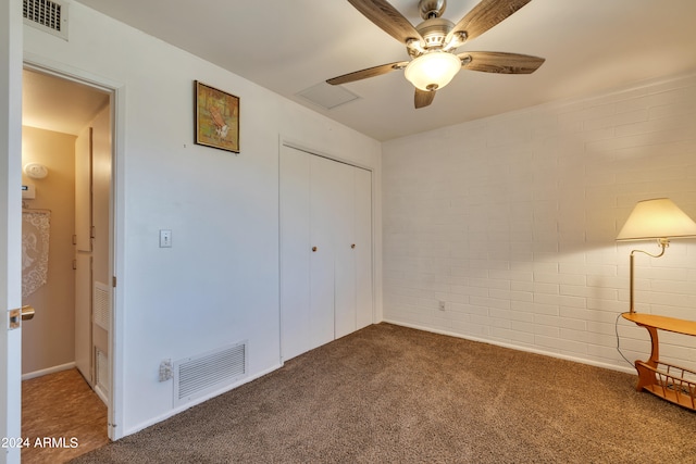 unfurnished bedroom featuring ceiling fan, a closet, and dark carpet