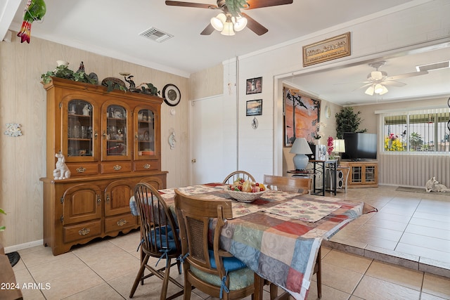 tiled dining area with ornamental molding and ceiling fan