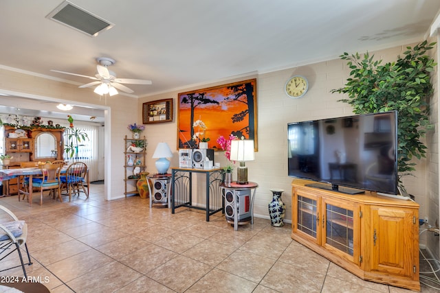 tiled living room with ceiling fan and crown molding