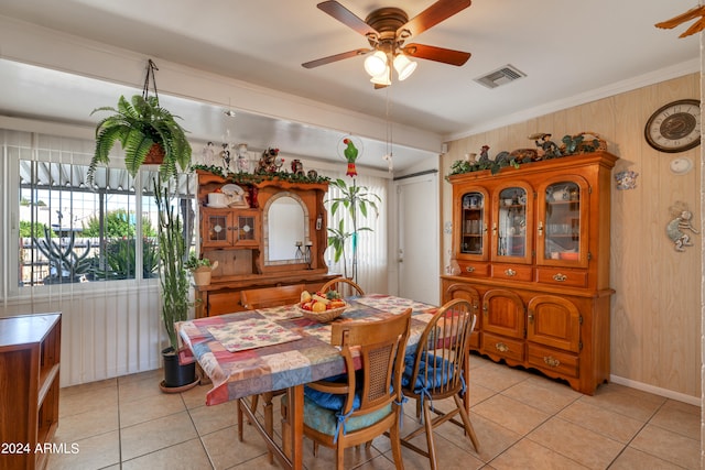 tiled dining room with ornamental molding and ceiling fan