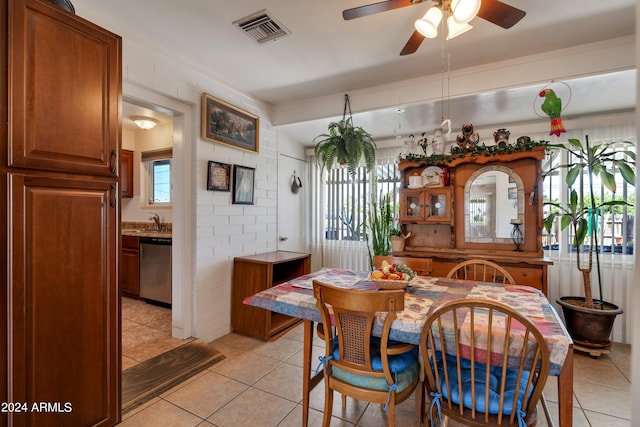 dining space with sink, ceiling fan, and light tile floors