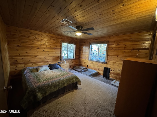 bedroom featuring carpet, ceiling fan, wood walls, and wooden ceiling