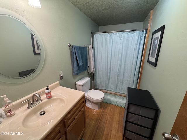 bathroom with vanity, a textured ceiling, hardwood / wood-style flooring, and toilet