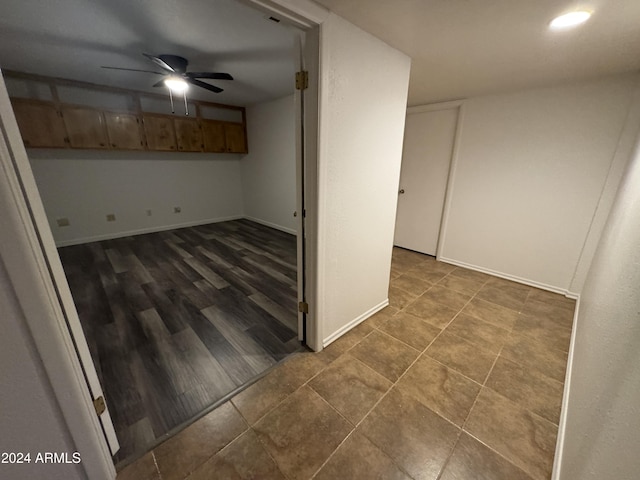 basement with dark hardwood / wood-style flooring and ceiling fan