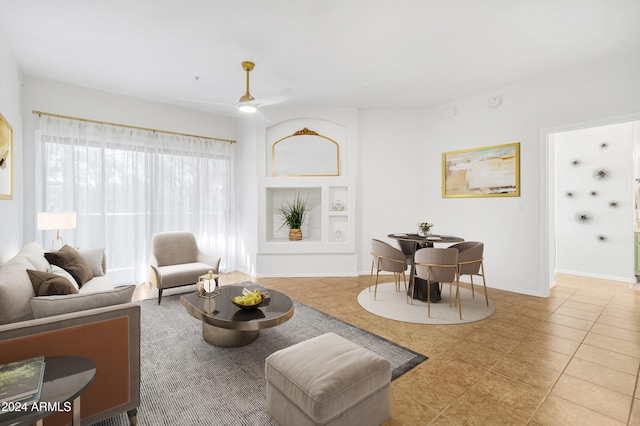 tiled living room featuring ceiling fan and built in features