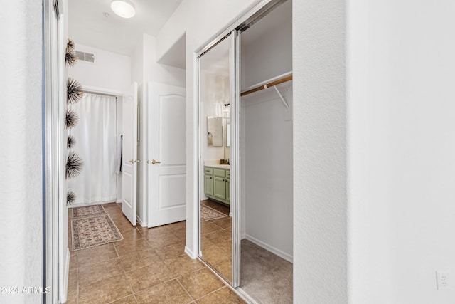 bathroom featuring tile patterned flooring, vanity, and walk in shower