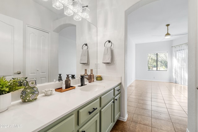 bathroom featuring tile patterned flooring, vanity, and ceiling fan with notable chandelier