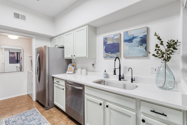 kitchen featuring sink, white cabinetry, stainless steel appliances, and light tile patterned floors