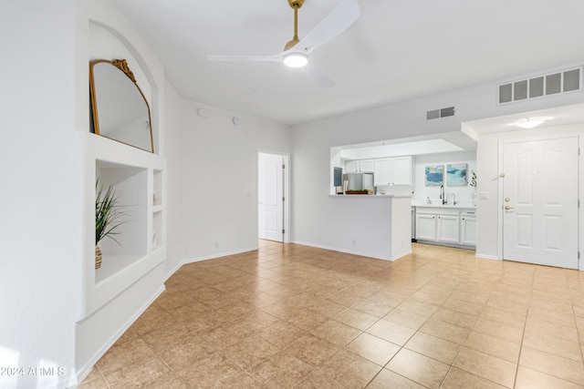 unfurnished living room featuring ceiling fan, light tile patterned floors, and built in shelves