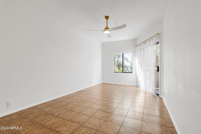 tiled spare room featuring ceiling fan