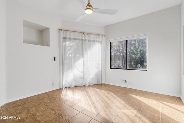 empty room featuring tile patterned flooring and ceiling fan