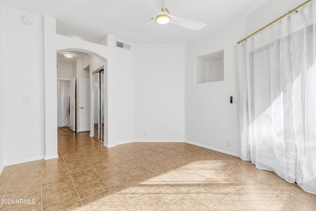 unfurnished room with ceiling fan and light tile patterned floors