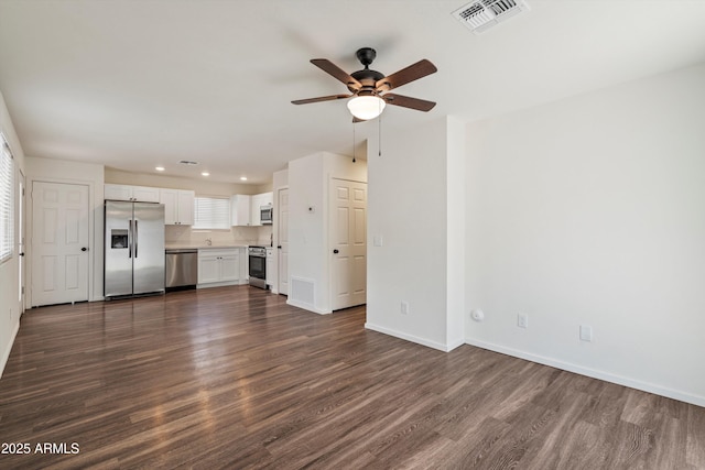 unfurnished living room featuring ceiling fan and dark wood-type flooring