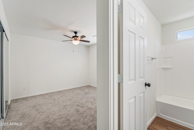 interior space with washtub / shower combination and ceiling fan