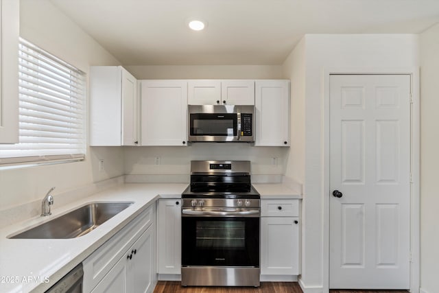 kitchen with sink, white cabinets, and stainless steel appliances